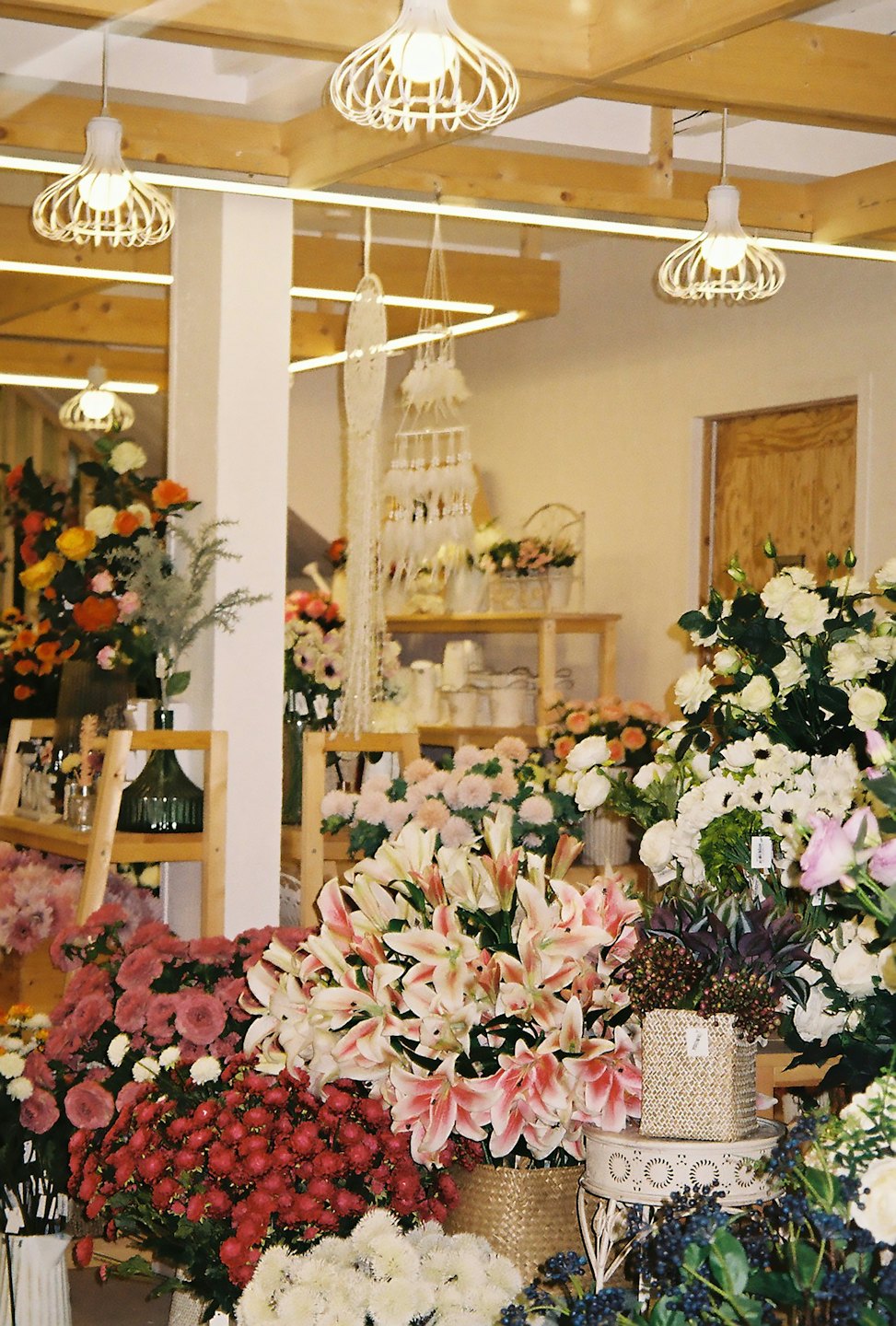 Färgglada blommor i korgar i en blomsterbutik.
